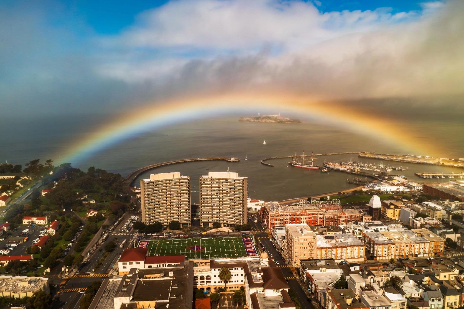 Rainbow spanning the northern San Francisco waterfront with Alcatraz centered beyond the marina