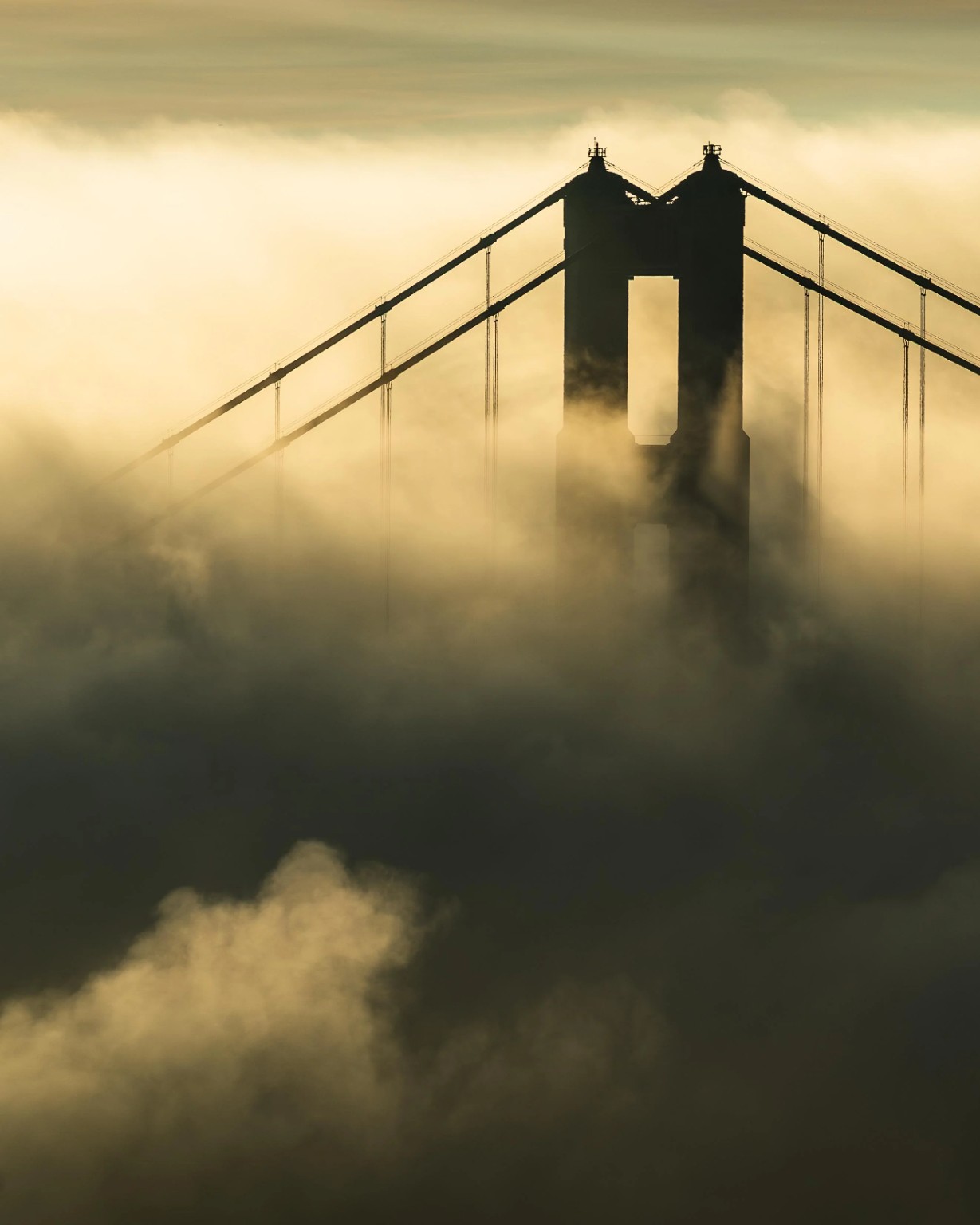 Full moon positioned above the Golden Gate Bridge tower and waterfront